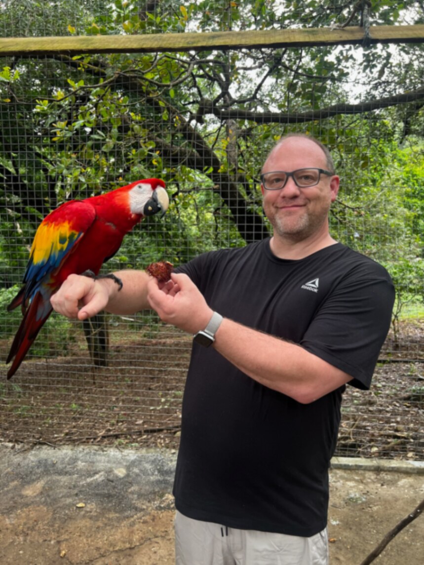 Jamian Wakefield feeding a scarlet macaw on a trip